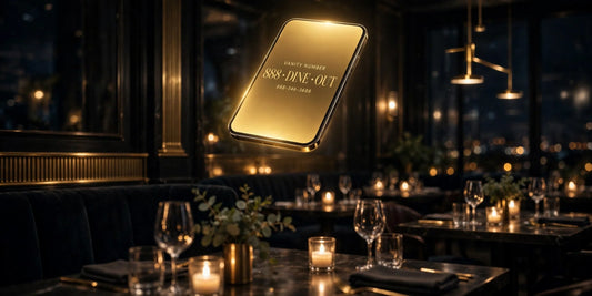 Golden smartphone showing a memorable vanity phone number above a candlelit luxury restaurant dining room